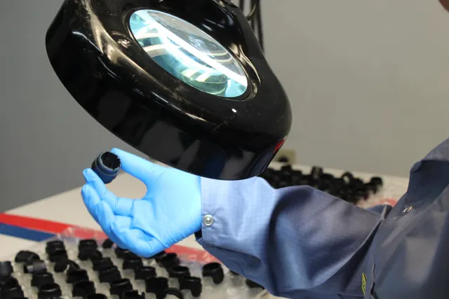 Inspector checking a part under a magnifier
