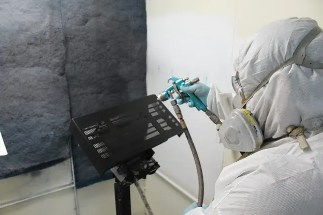 Operator spray painting a part